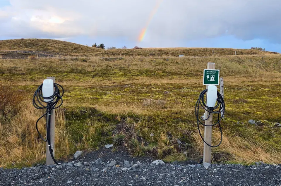 Two EV charging points at Eyvindarholt with a rainbow above the hills