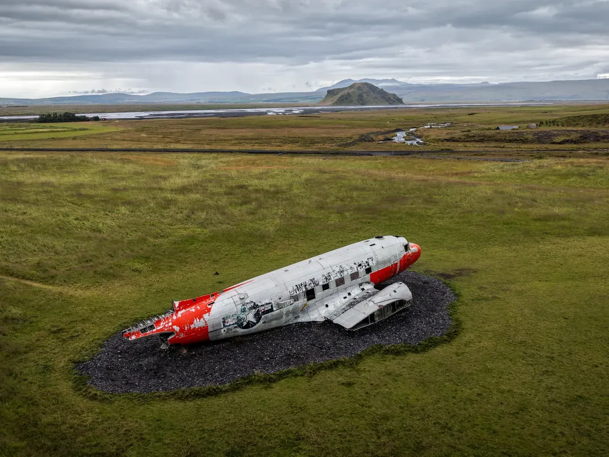 Aerial view of the orange and white DC-3 and its surroundings at Eyvindarholt