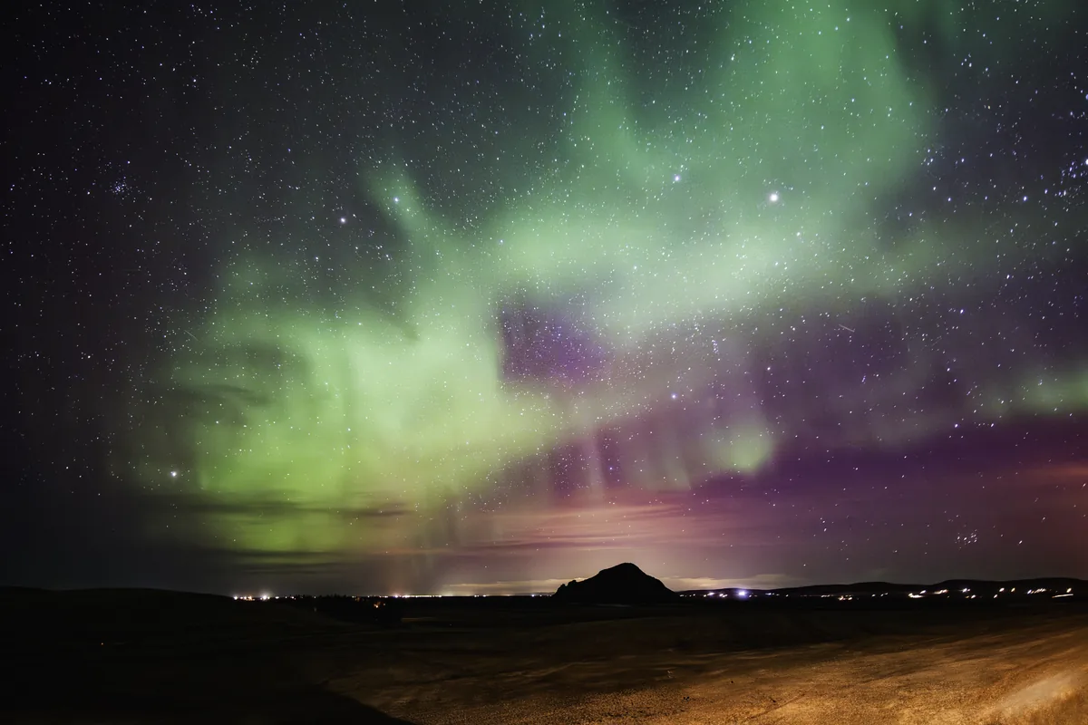 Green aurora dancing above the open South Iceland horizon